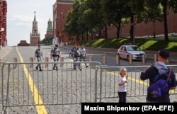 Люди у шлагбаума на Красной площади в Москве 25 июня.