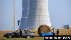 Belarus - People transporting a bundle of straw close to the construction site of the first Belarus' nuclear power plant outside the town of Astravets, some 170 km northwest of Minsk, 19Aug2017