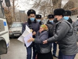 Полиция задерживает протестующую более 300 дней у консульства Китая в Алматы. 8 декабря 2021 года.