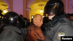 ОМОН задерживает в Петербурге участника акции протеста в маске Владимира Путина