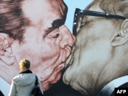 East Side Gallery көрмесіндегі Совет Одағының бірінші хатшысы болған Леонид Брежнев пен ГДР жетекшісі болған Эрих Хонеккердің сүйісіп тұрғандарын бейнелейтін әйгілі сықақ сурет.