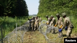 Літоўскія вайскоўцы ставяць агароджу на мяжы зь Беларусьсю.