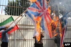 Iran -- İranlı kişi ABŞ, Britaniya və İsrail bayraqlarını yandırır, 2 sentyab 2015