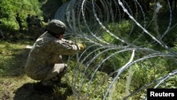 Літоўскія вайскоўцы робяць агароджу на мяжы зь Беларусьсю