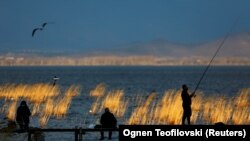 NORTH MACEDONIA -- Fishermen fish on the dock at Dojran lake in Dojran, North Macedonia March 2, 2019