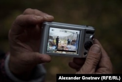 Нина Шалаева показывает фотографию полицейских, приезжавших в лагерь