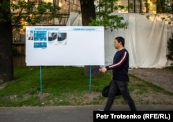 Қазақстан президенттігіне кандидаттардың сайлау жарнамаларының қасынан өтіп бара жатқан адам. Алматы, 13 мамыр 2019 жыл.