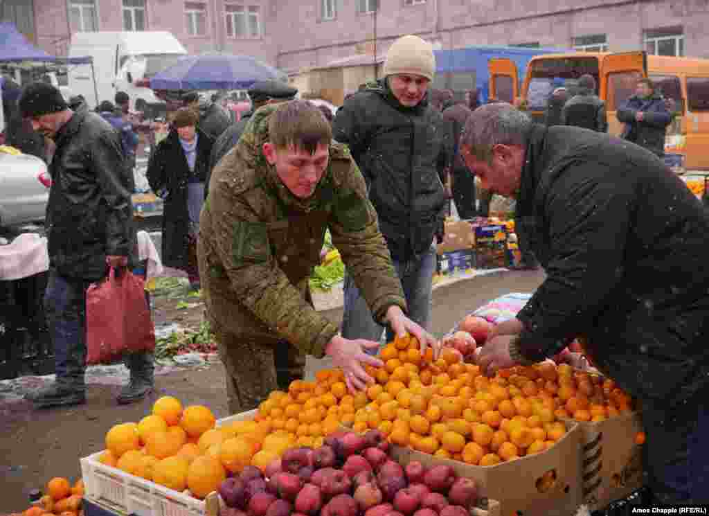 Российский военнослужащий покупает мандарины на центральном рынке Гюмри. Во время расследования убийства семьи Аветисян было выявлено масштабное хищение продуктов, на сумму в 7 миллионов 800 тысяч долларов, предназначавшихся Минобороны России для питания своих военнослужащих в Армении. Все продукты были украдены и перепроданы на местных рынках &nbsp;