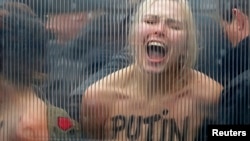 Активистка FEMEN протестует против визита Путина в Брюссель (надпись на груди девушки: "Путин – убийца демократии"), 28 января 2014 года