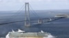 Denmark -- The Royal Caribbean's new cruise ship "Liberty of the Seas" sails under the Storebelt bridge in Denmark on her maiden voyage to Southampton, undated