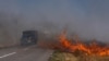 Cars drive along a burning field near Pokrovsk, Donetsk region, on September 16, 2024, amid the Russian invasion of Ukraine.