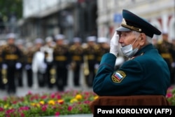 Ветеран в маске ждет начала парада Победы